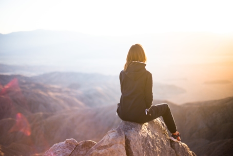 woman sitting outside with back turned
